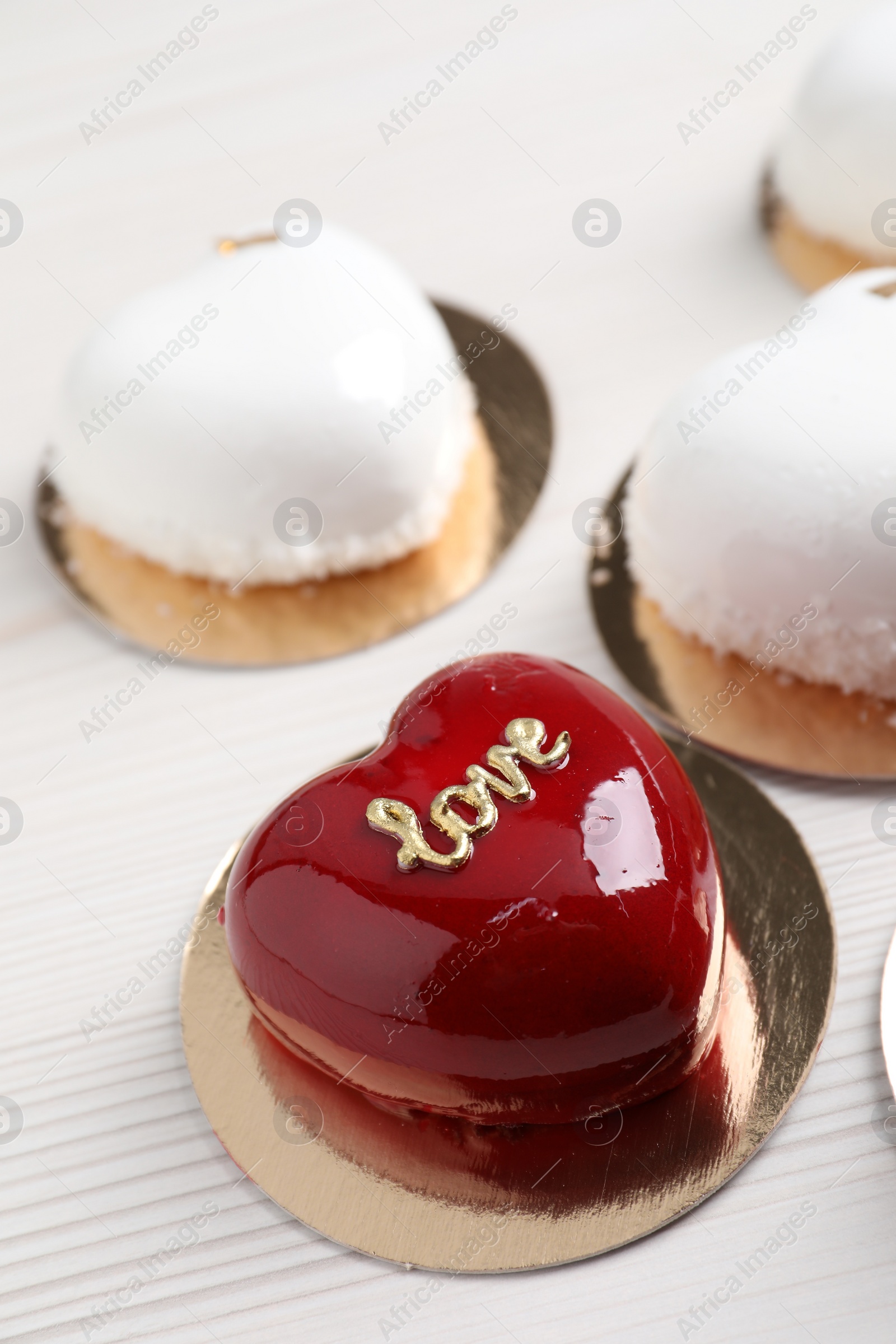 Photo of St. Valentine's Day. Delicious heart shaped cakes on white wooden table, closeup