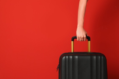 Photo of Woman with stylish suitcase against color background, closeup. Space for text