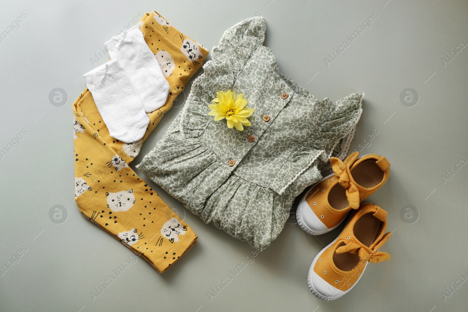 Photo of Stylish child clothes and shoes on grey background, flat lay