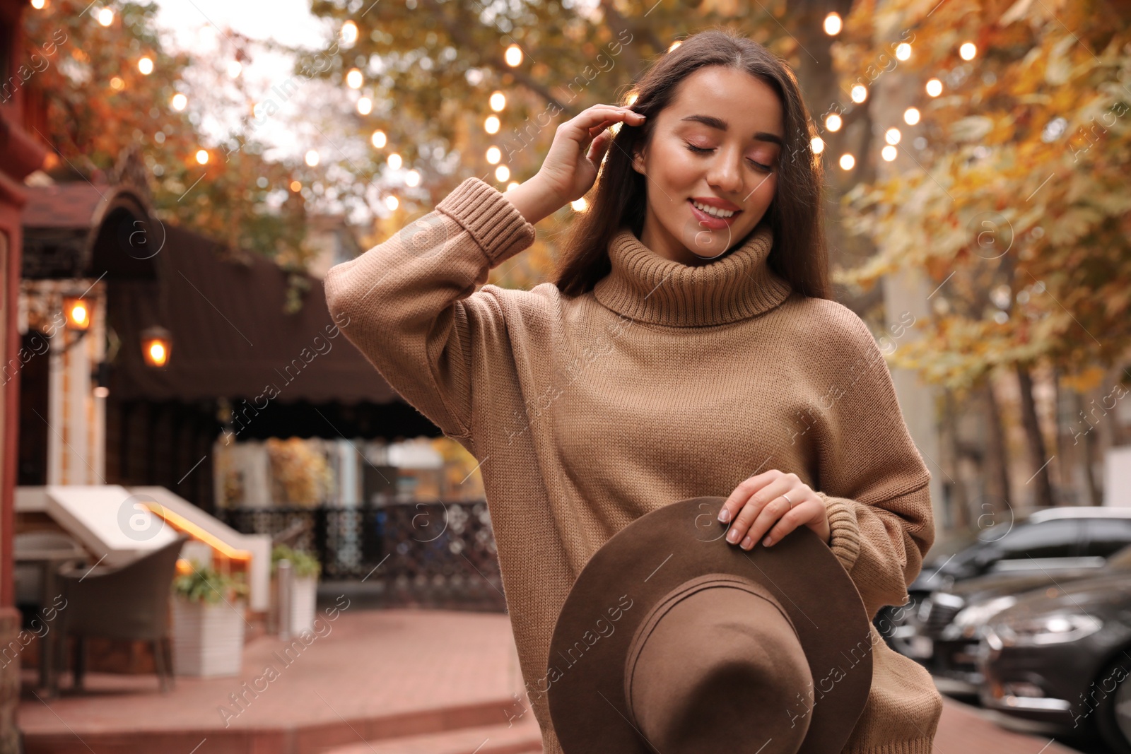 Photo of Young woman wearing stylish clothes on city street. Autumn look