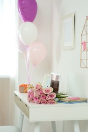 Photo of Beautiful flowers, gifts and balloons on white table in room. Happy birthday greetings