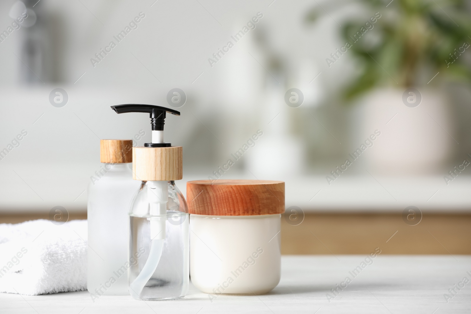 Photo of Personal care products and towel on white wooden table in bathroom. Space for text