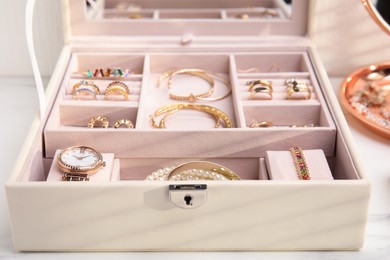 Photo of Jewelry box with stylish golden bijouterie on white table