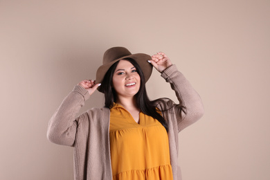Photo of Beautiful overweight woman posing on beige background. Plus size model