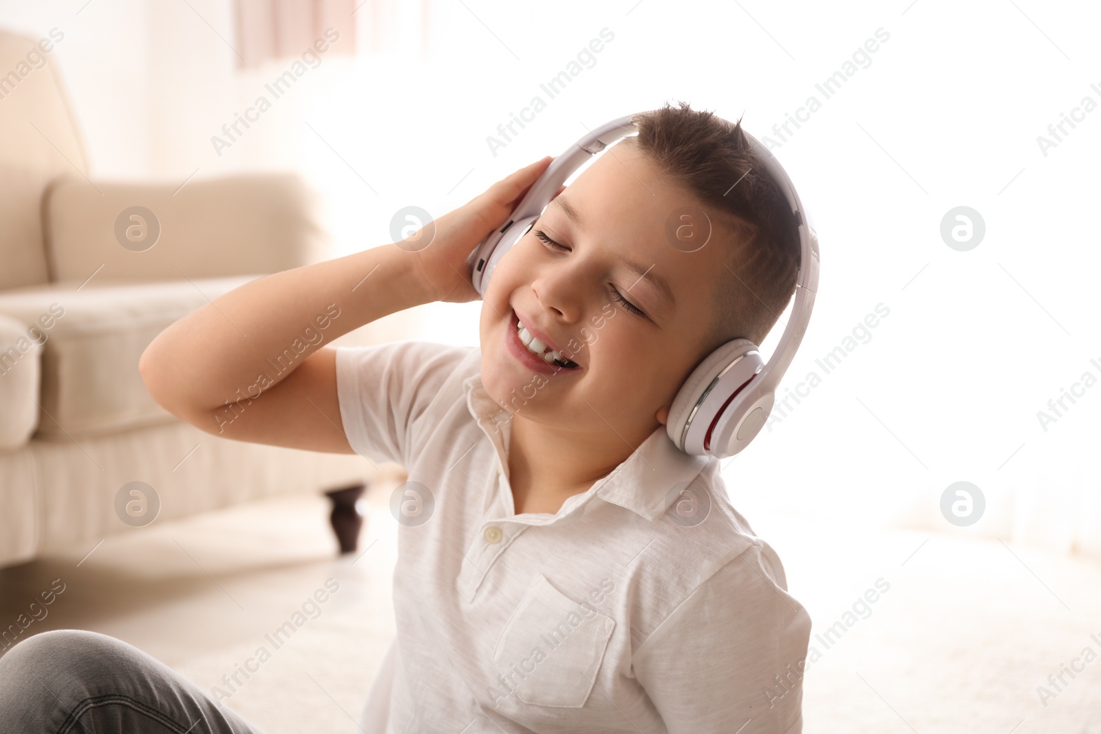 Photo of Little boy listening to music at home