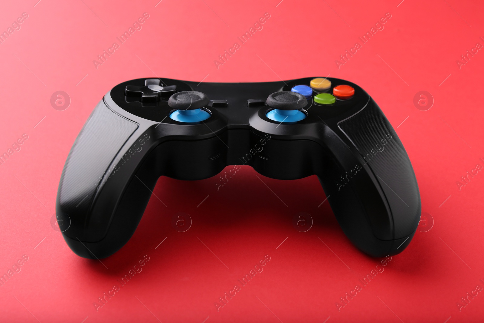 Photo of One wireless game controller on red background