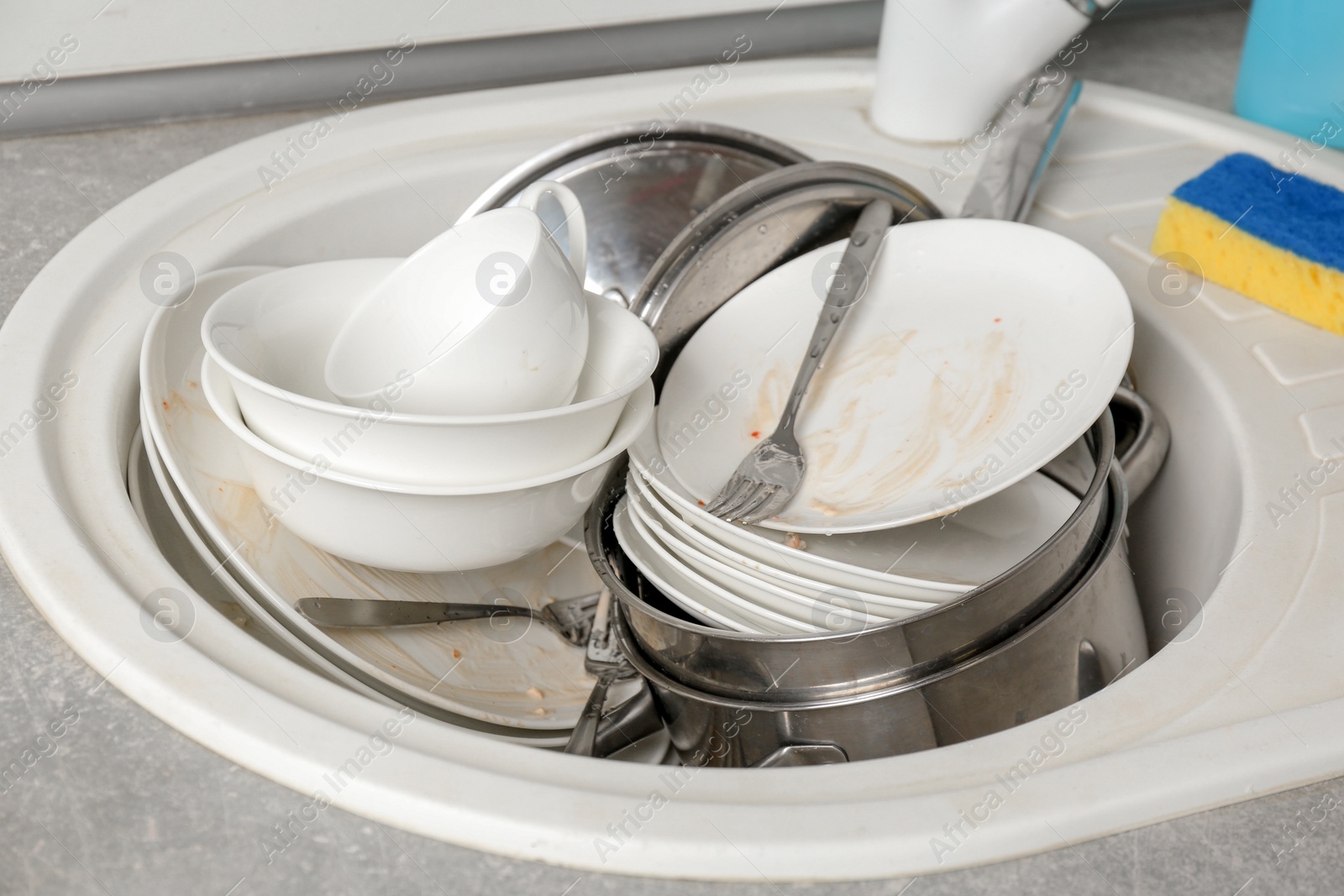 Photo of Messy pile of dirty dishes in sink