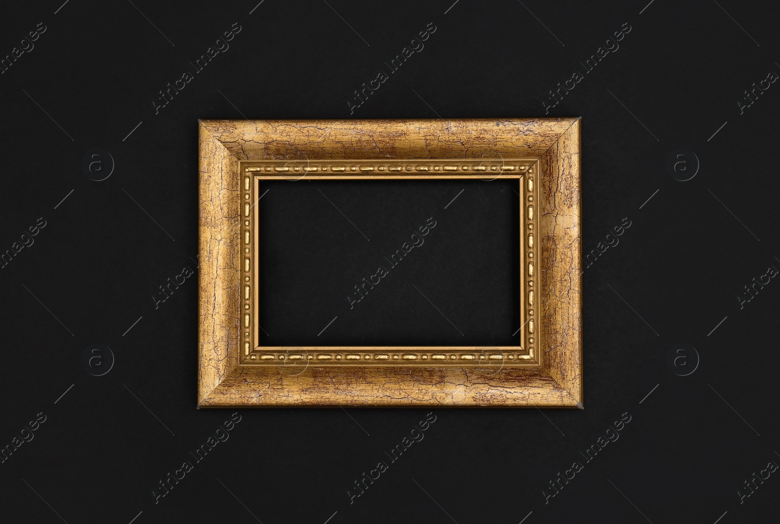Photo of Gold painted frame on black background, top view with space for text