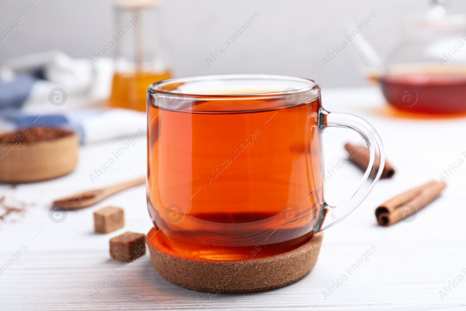 Photo of Freshly brewed rooibos tea on white wooden table
