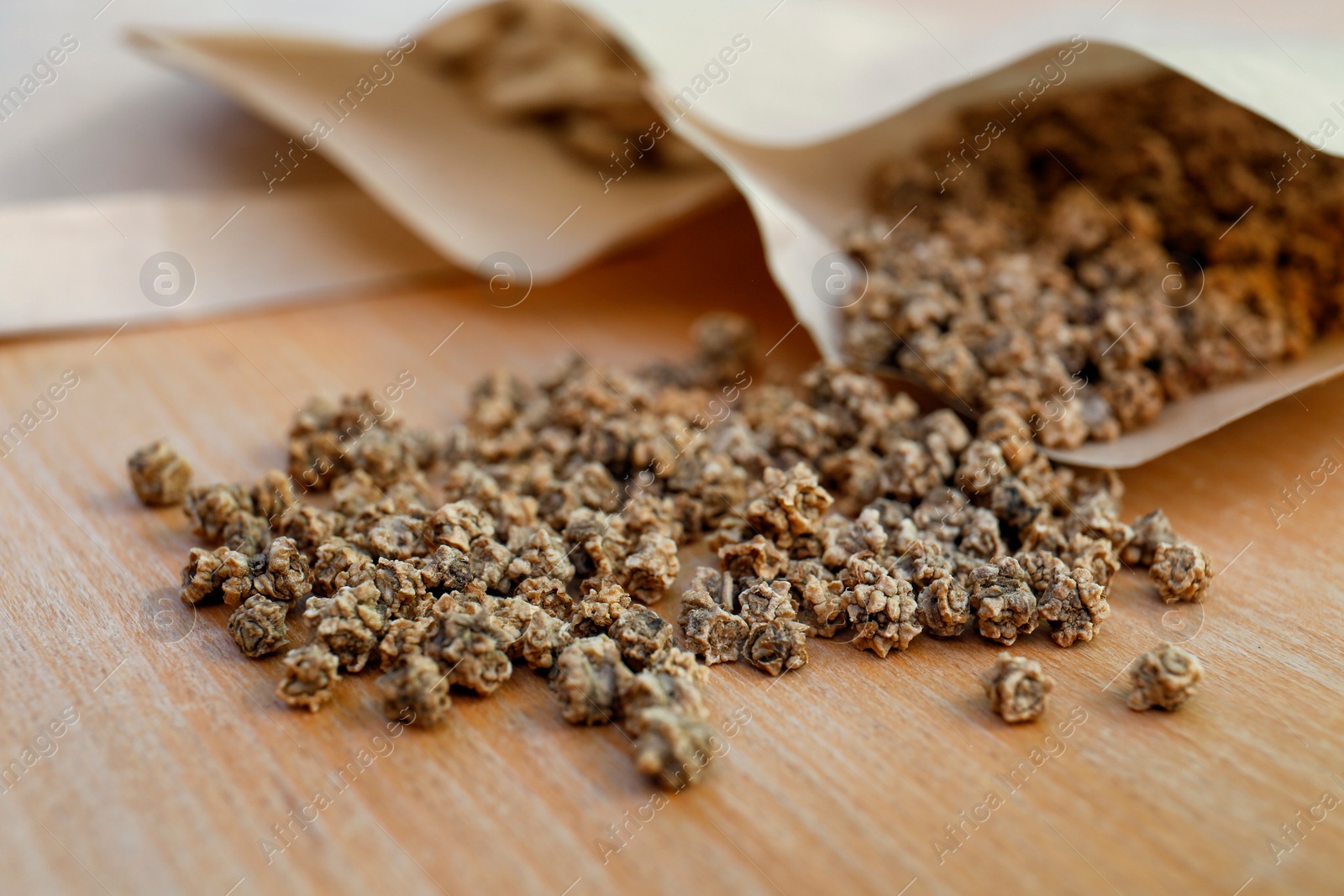 Photo of Paper bags with beet seeds on wooden table, closeup. Vegetable planting