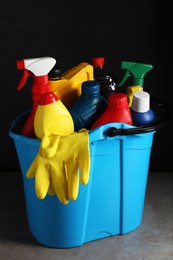 Photo of Light blue bucket with car cleaning products on grey table