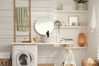 Photo of Stylish bathroom interior with modern washing machine