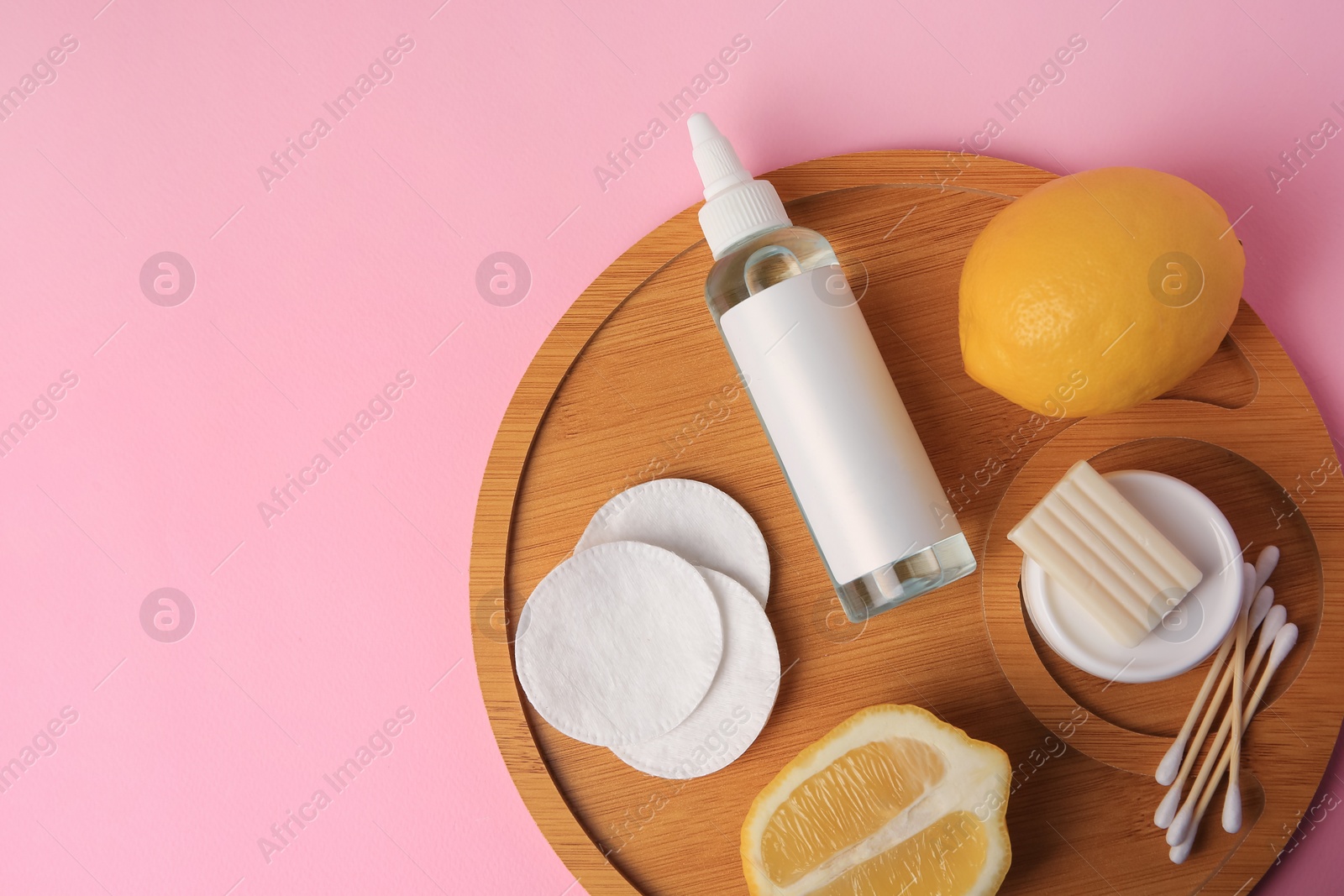 Photo of Lemon face cleanser. Fresh citrus fruits and personal care products on pink background, top view. Space for text