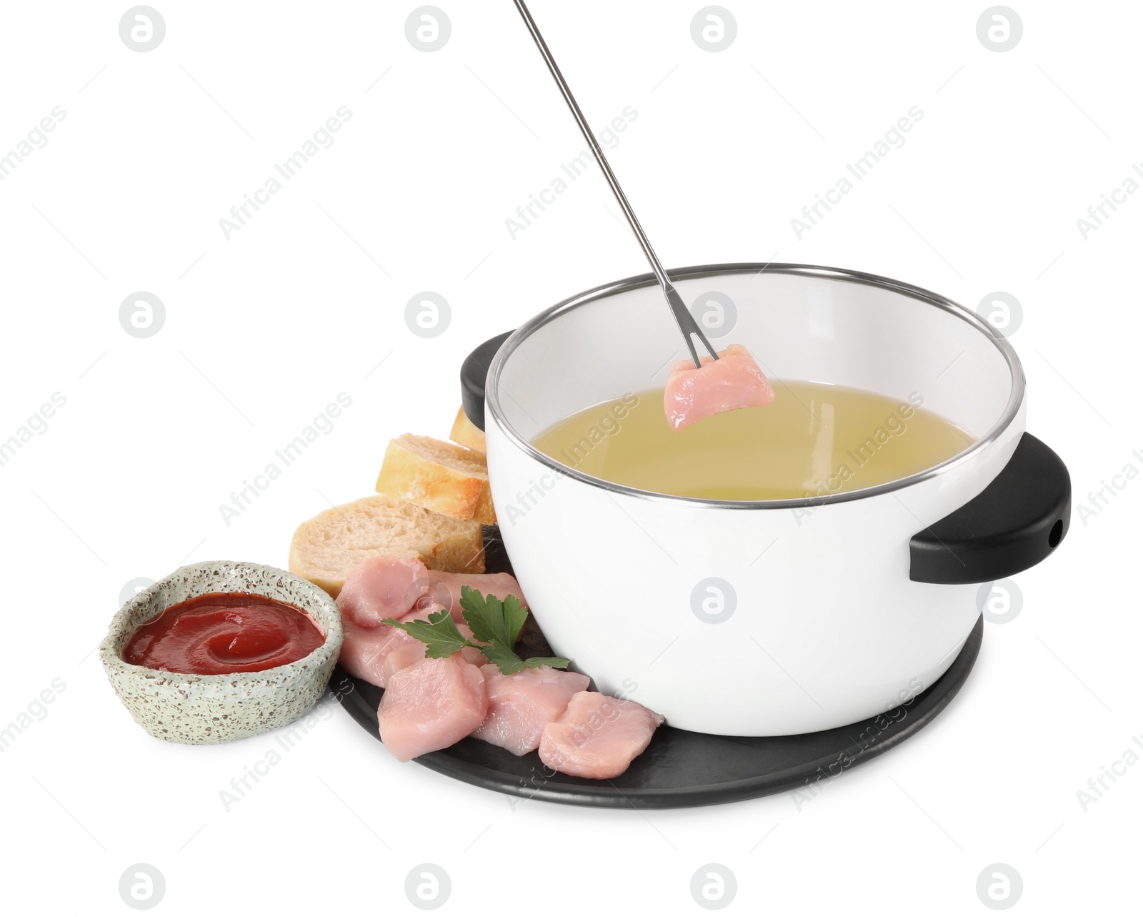Photo of Dipping piece of raw meat into oil in fondue pot on white background