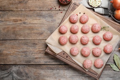Photo of Many fresh raw meatballs on wooden table, flat lay Space for text