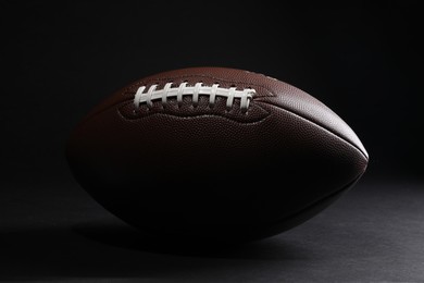 Photo of Leather American football ball on black background