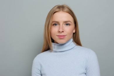 Portrait of beautiful young woman on grey background