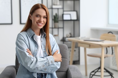 Photo of Portrait of beautiful young woman with red hair at home. Attractive lady smiling and looking into camera. Space for text