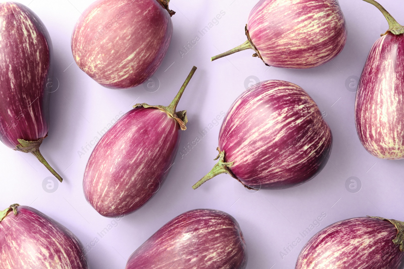 Photo of Raw ripe eggplants on light background, flat lay