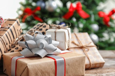 Beautiful gift boxes and blurred Christmas tree on background