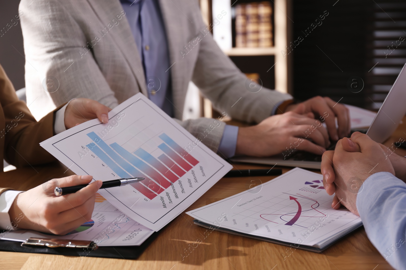 Photo of Business people working with charts and graphs at table in office, closeup. Investment analysis