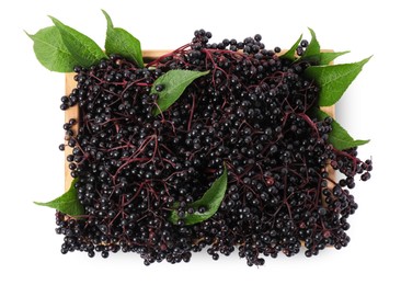Photo of Crate with ripe elderberries and green leaves isolated on white , top view
