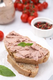 Photo of Delicious liverwurst sandwich with basil on white table