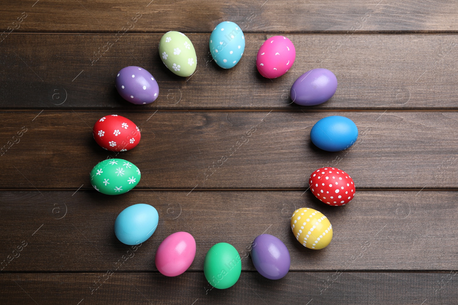 Photo of Frame of colorful eggs on wooden background, flat lay with space for text. Happy Easter