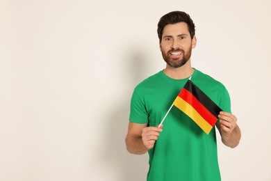 Man with flag of Germany on white background, space for text
