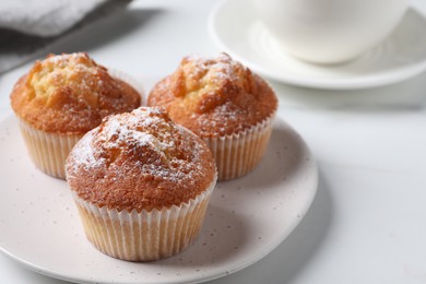 Photo of Delicious sweet muffins on white table, closeup. Space for text