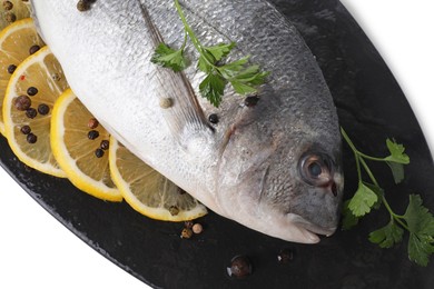 Photo of Raw dorado fish, parsley, lemon slices and peppercorns isolated on white