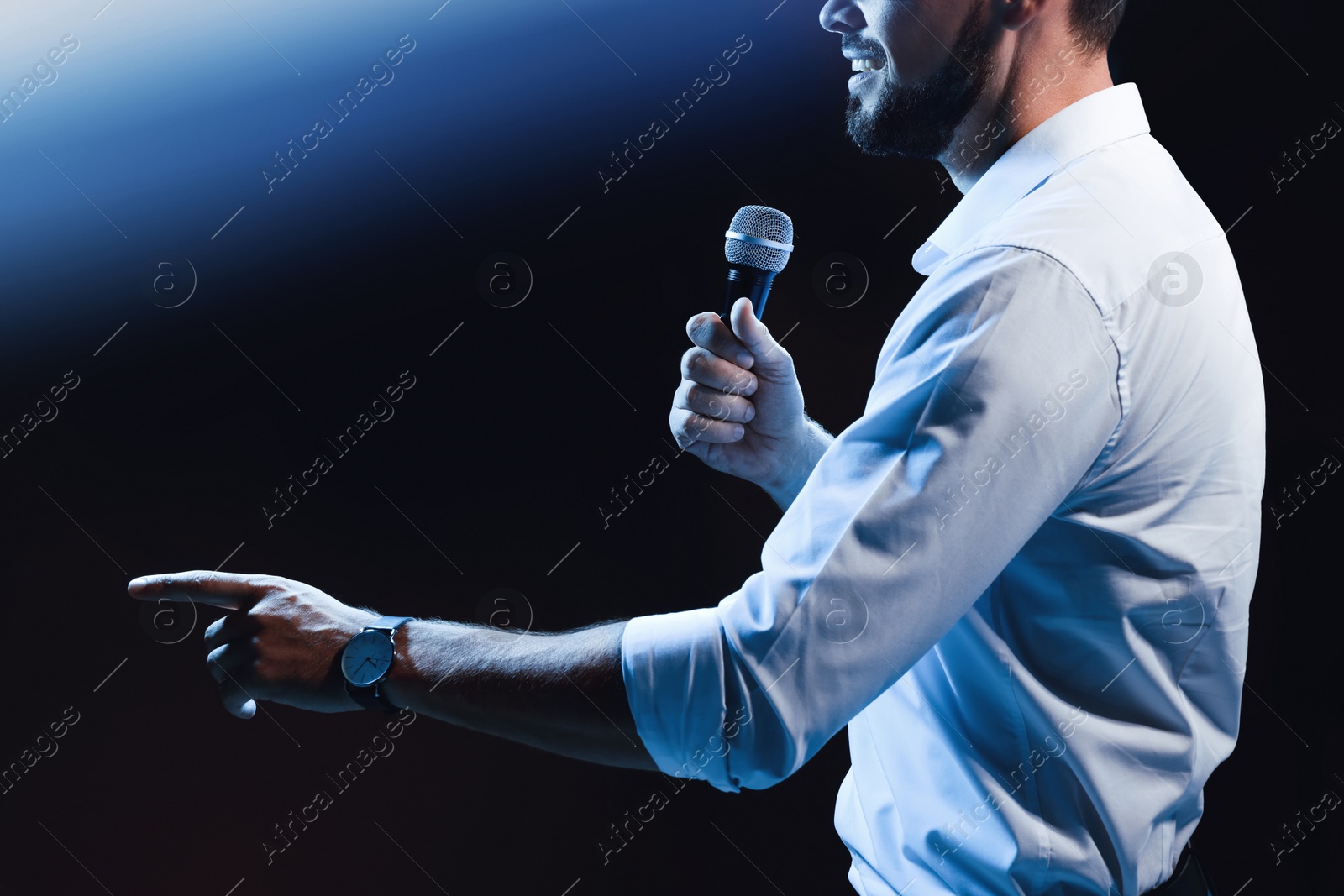 Photo of Motivational speaker with microphone performing on stage, closeup