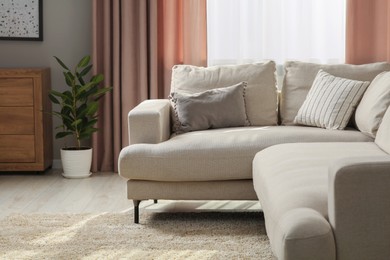 Photo of Stylish sofa with cushions in living room. Interior design