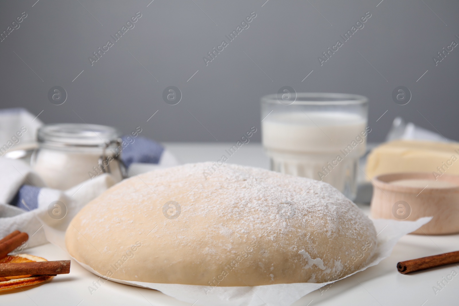 Photo of Fresh dough and ingredients on white table, closeup