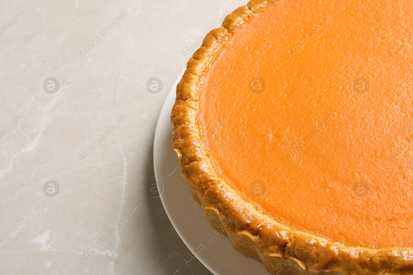 Photo of Fresh delicious homemade pumpkin pie on light table, closeup. Space for text