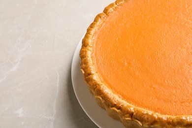 Photo of Fresh delicious homemade pumpkin pie on light table, closeup. Space for text