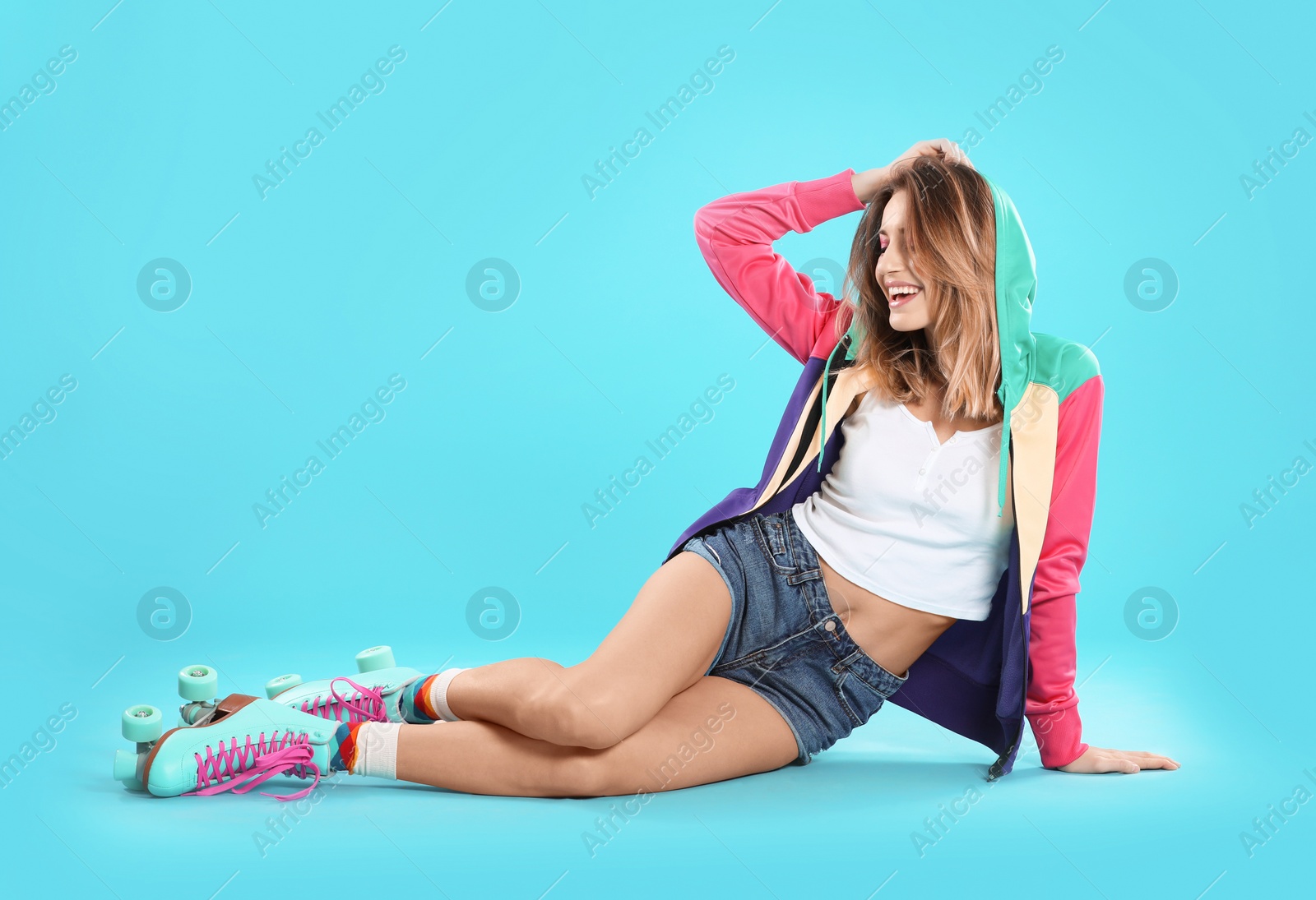 Photo of Young woman with retro roller skates on color background