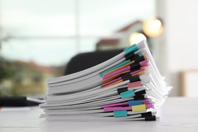 Stack of documents with paper clips on office table