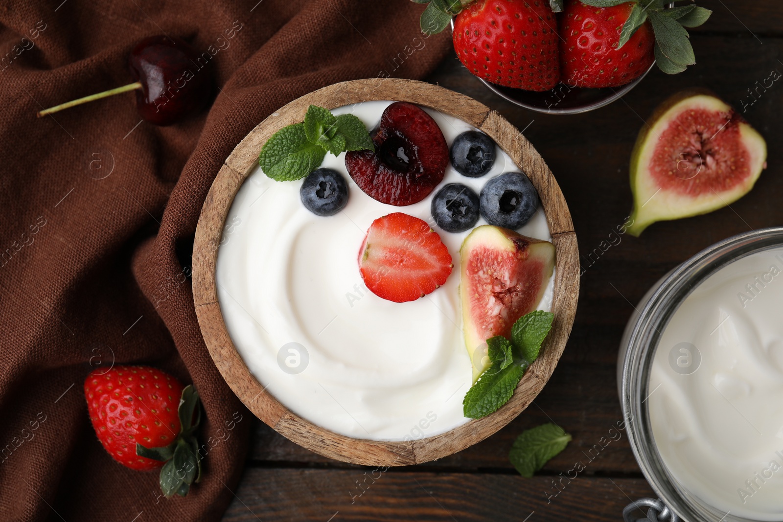 Photo of Tasty yogurt, berries, fruits and mint on wooden table, flat lay