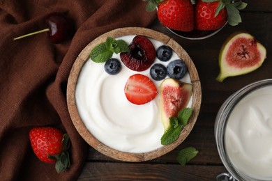 Tasty yogurt, berries, fruits and mint on wooden table, flat lay