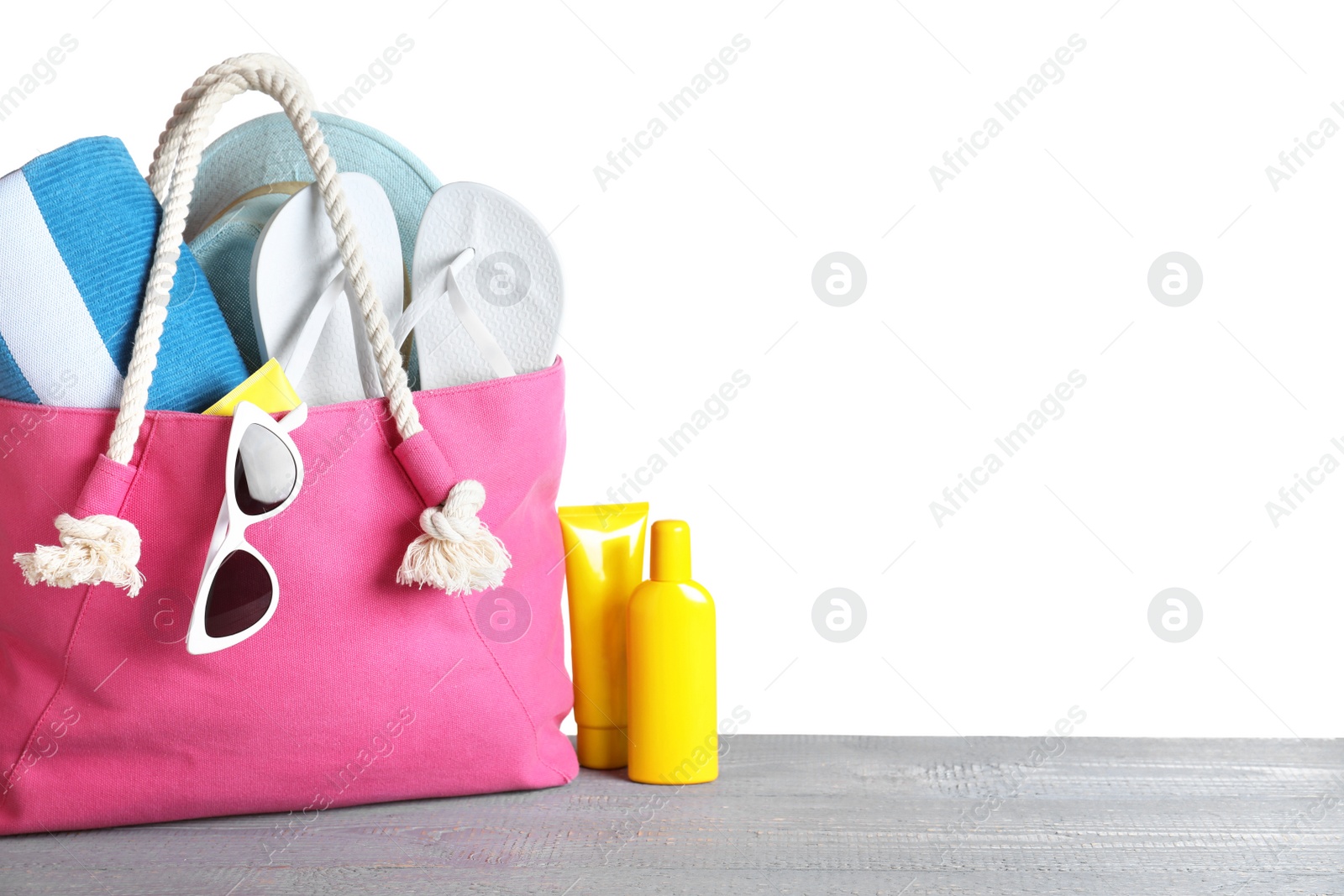 Photo of Composition with different beach objects on grey wooden table, white background