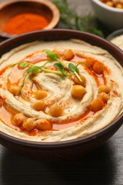 Delicious hummus with chickpeas on wooden table, closeup view