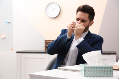Photo of Sick young man at workplace. Influenza virus