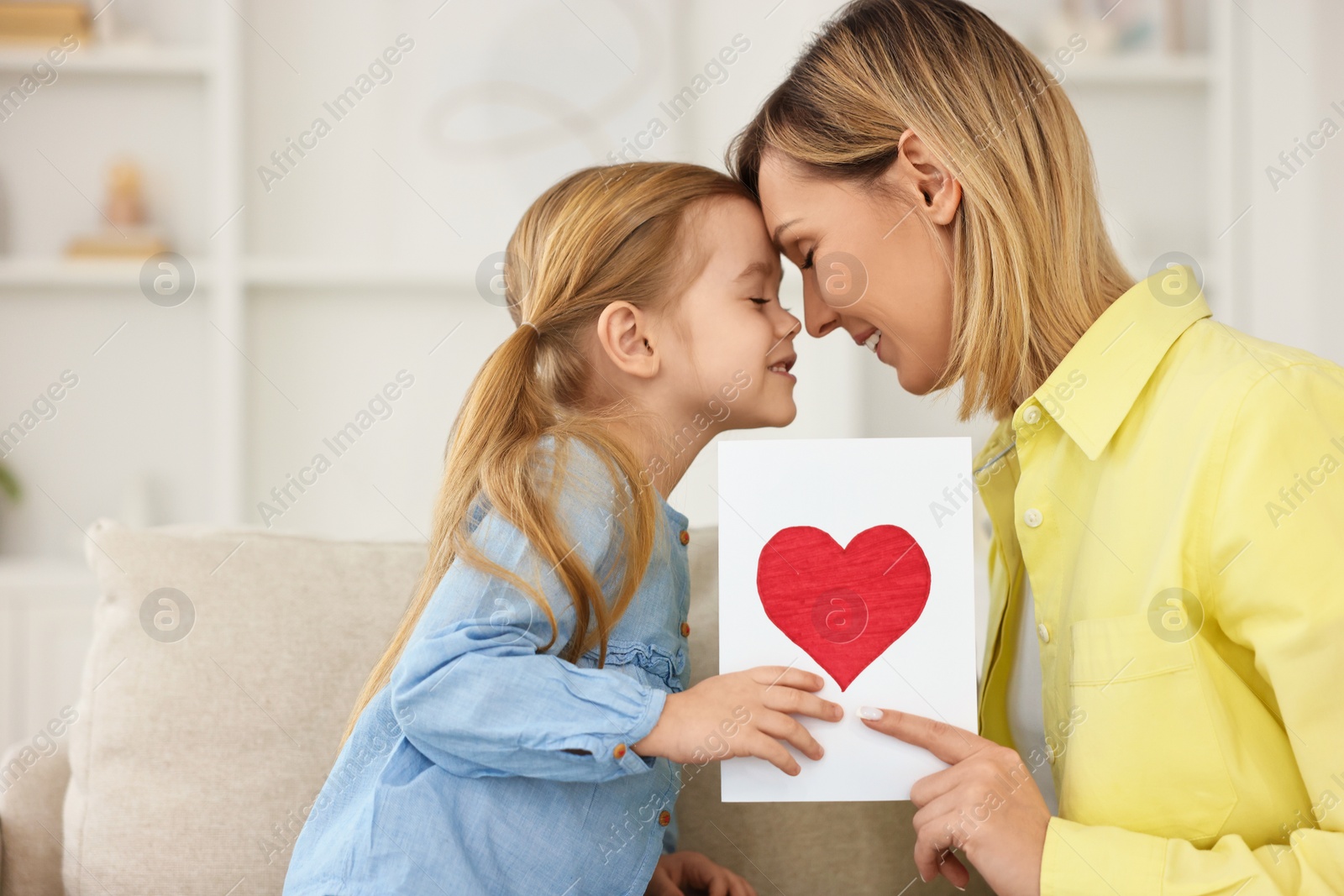 Photo of Little daughter congratulating her mom with greeting card at home, space for text. Happy Mother's Day