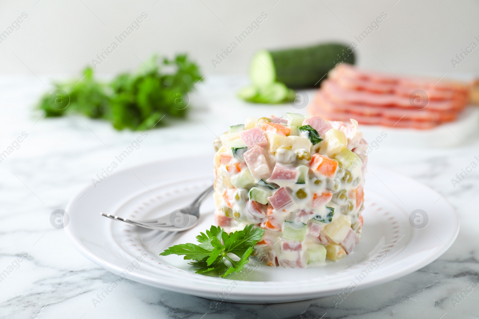 Photo of Delicious homemade salad Olivier on marble table