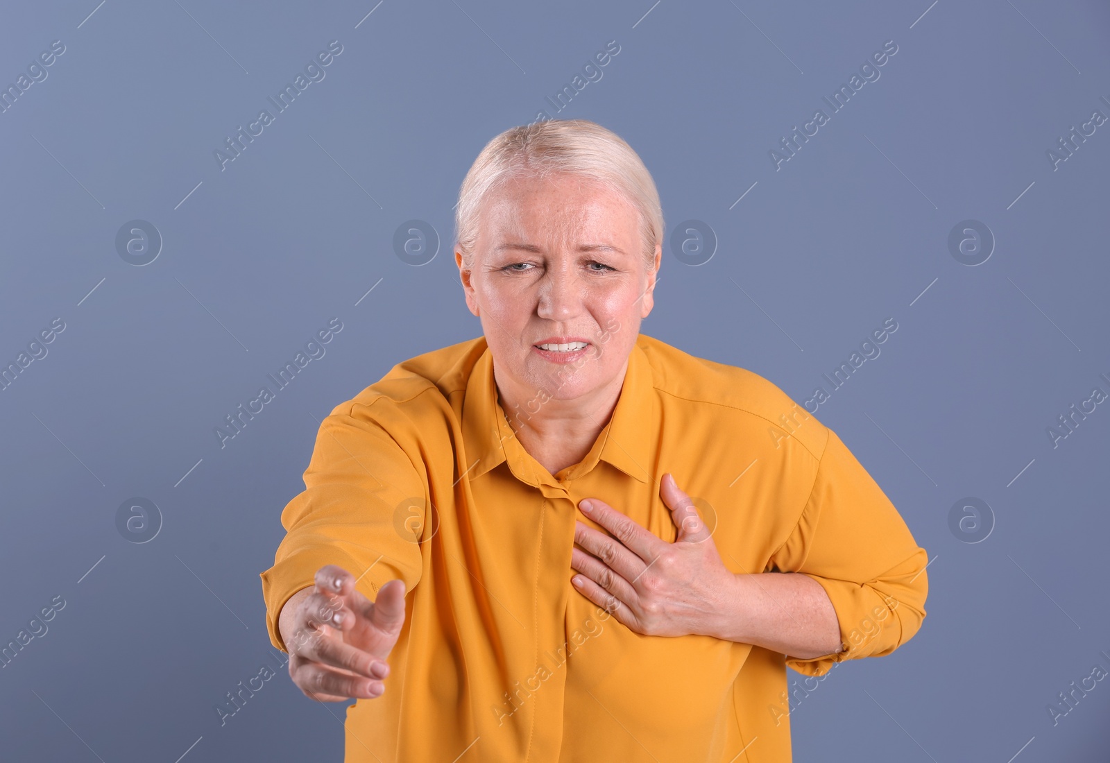 Photo of Mature woman having heart attack on color background