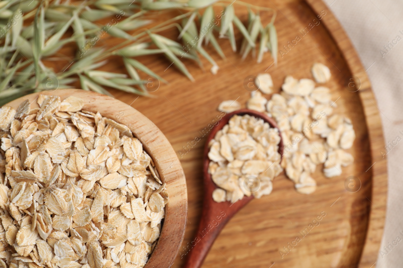 Photo of Oatmeal and branches with florets on table, flat lay. Space for text