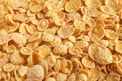 Photo of Crispy cornflakes as background, closeup. Healthy breakfast