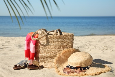 Photo of Stylish beach accessories on sandy sea shore