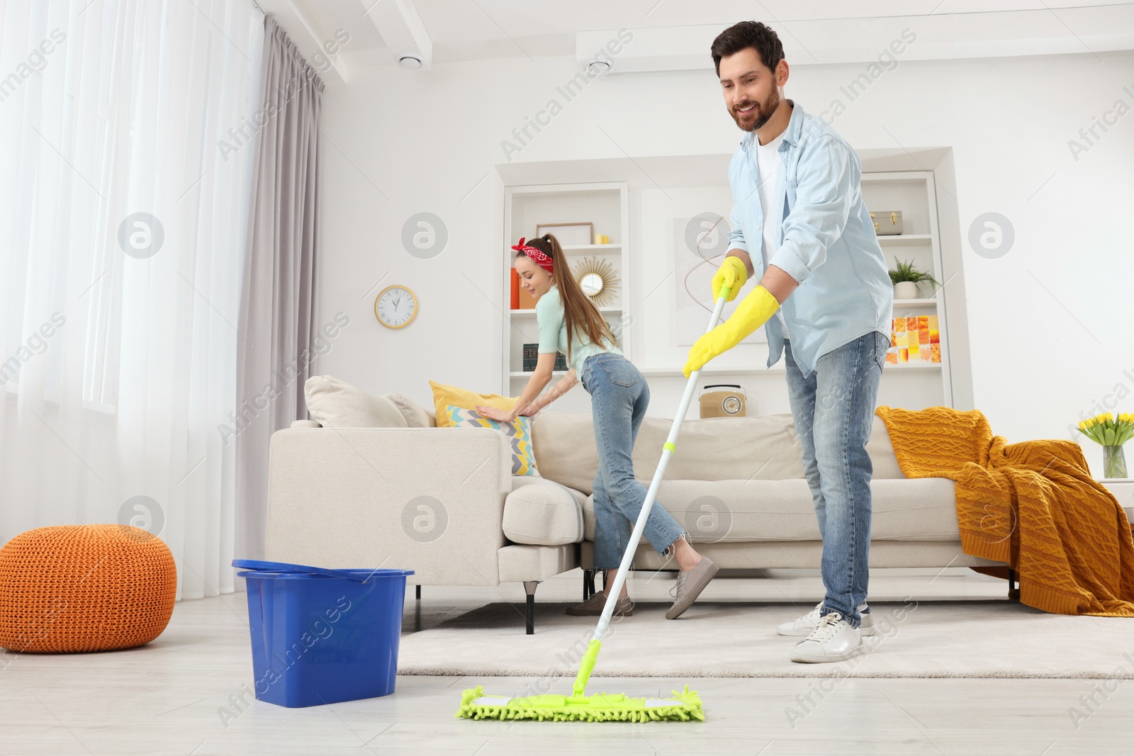 Photo of Spring cleaning. Couple tidying up living room together